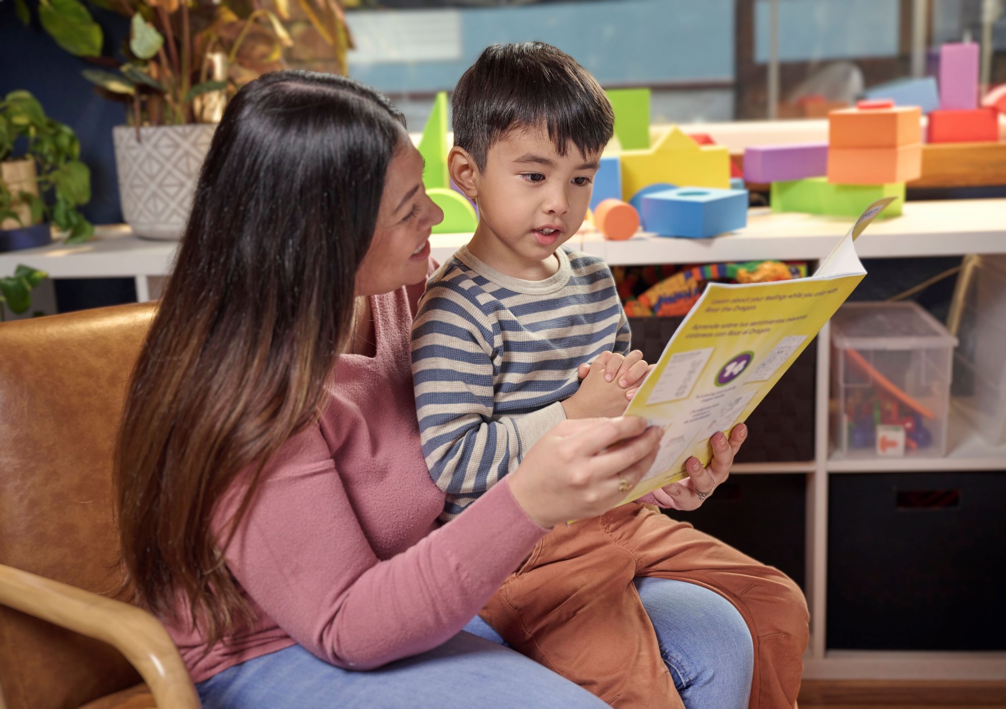 Asian mom reading a book to her child